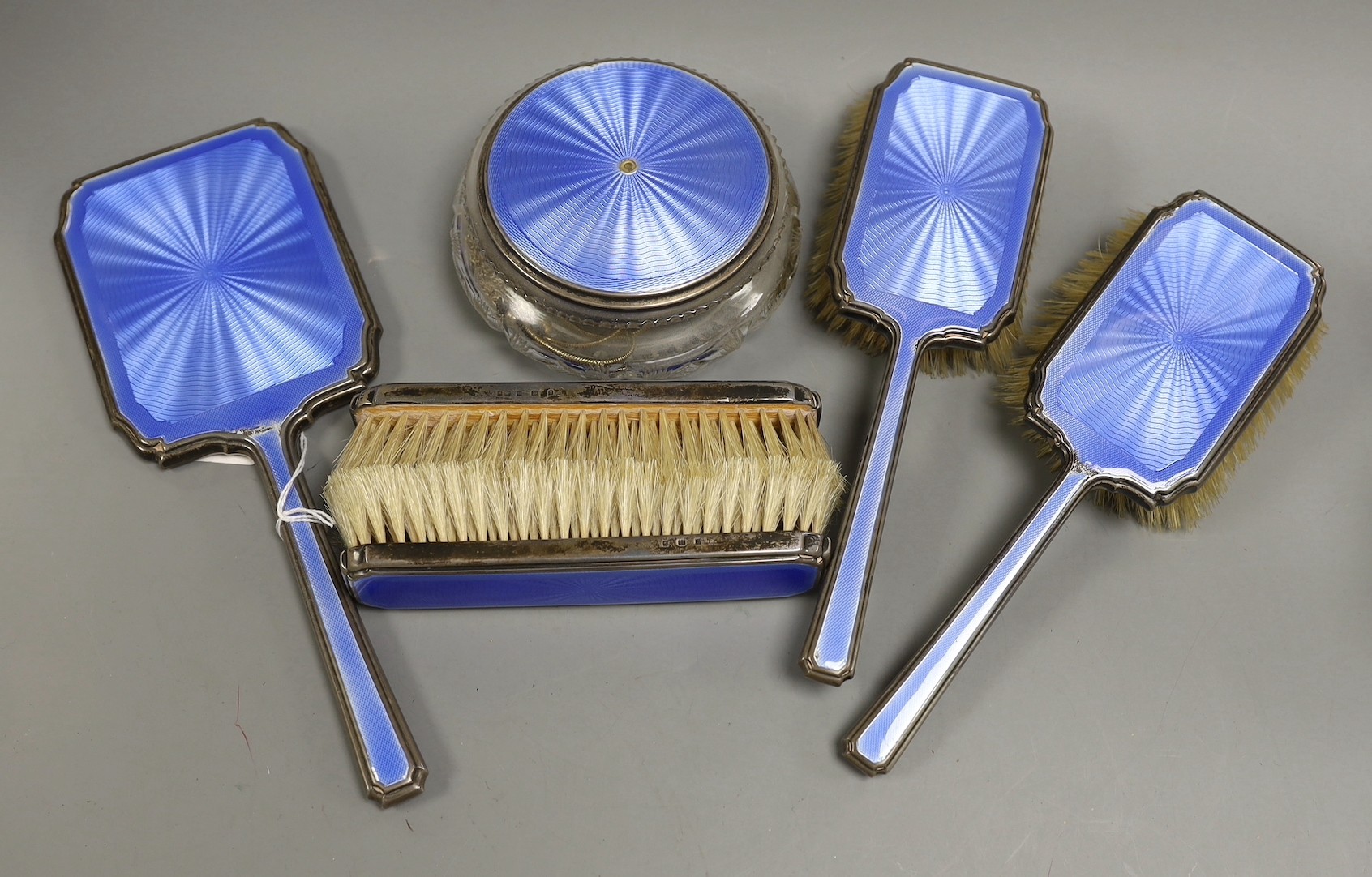 A 1930's silver and blue guilloche enamel six piece dressing table set, including hand mirror and toilet jar.